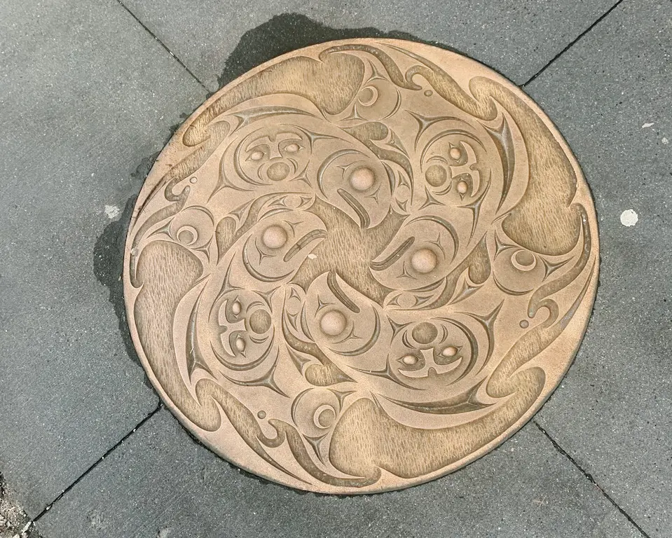 A manhole cover decorated with Salish, First Nations art